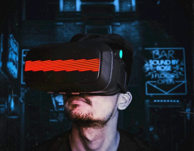 Young man immersed in a virtual reality experience using a VR headset, showcasing futuristic tech in a gaming environment.